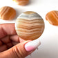 Banded Honey Calcite Round Palm Stone