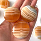 Banded Honey Calcite Round Palm Stone
